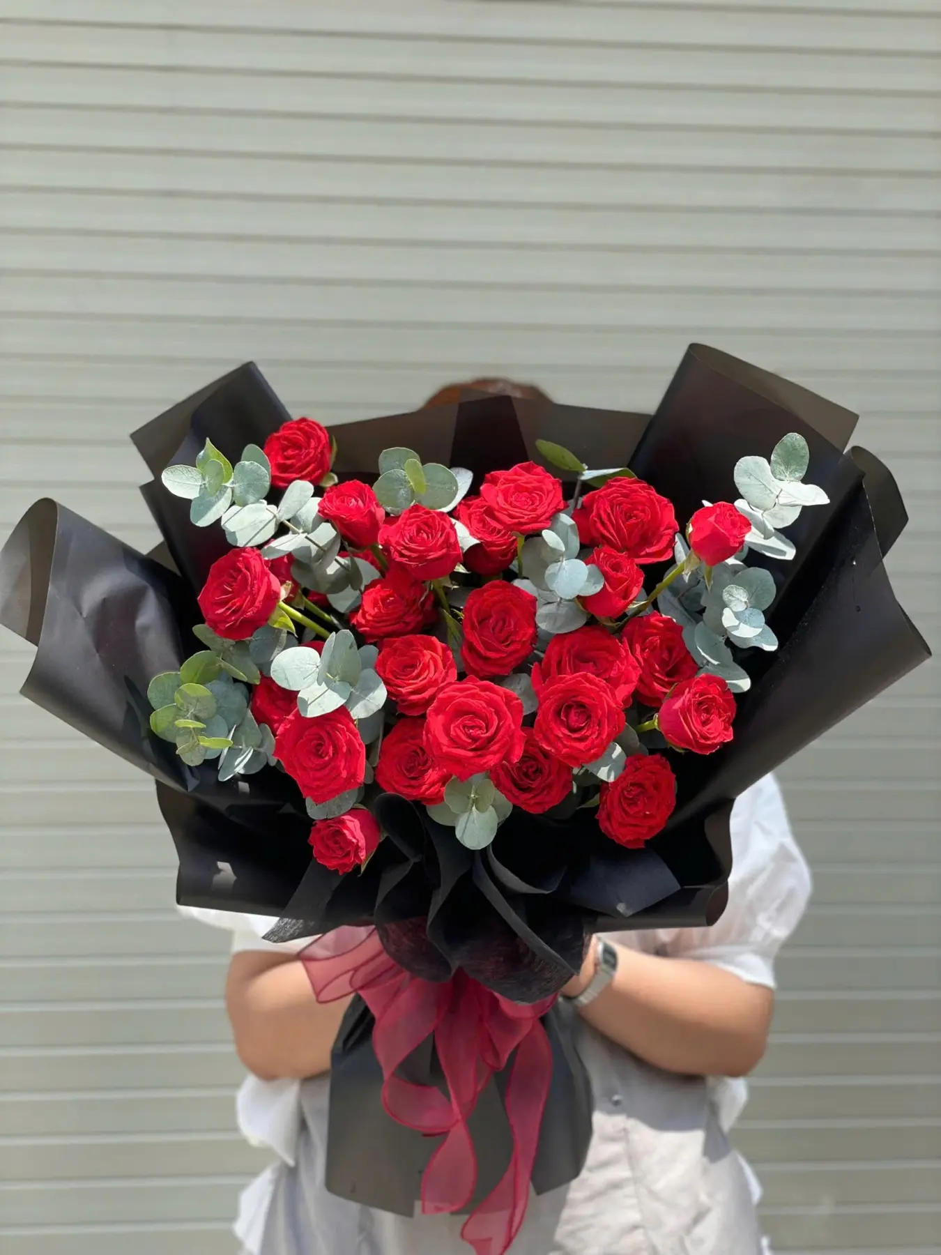 Bó hoa hồng đỏ phối lá bạc và giấy gói đen